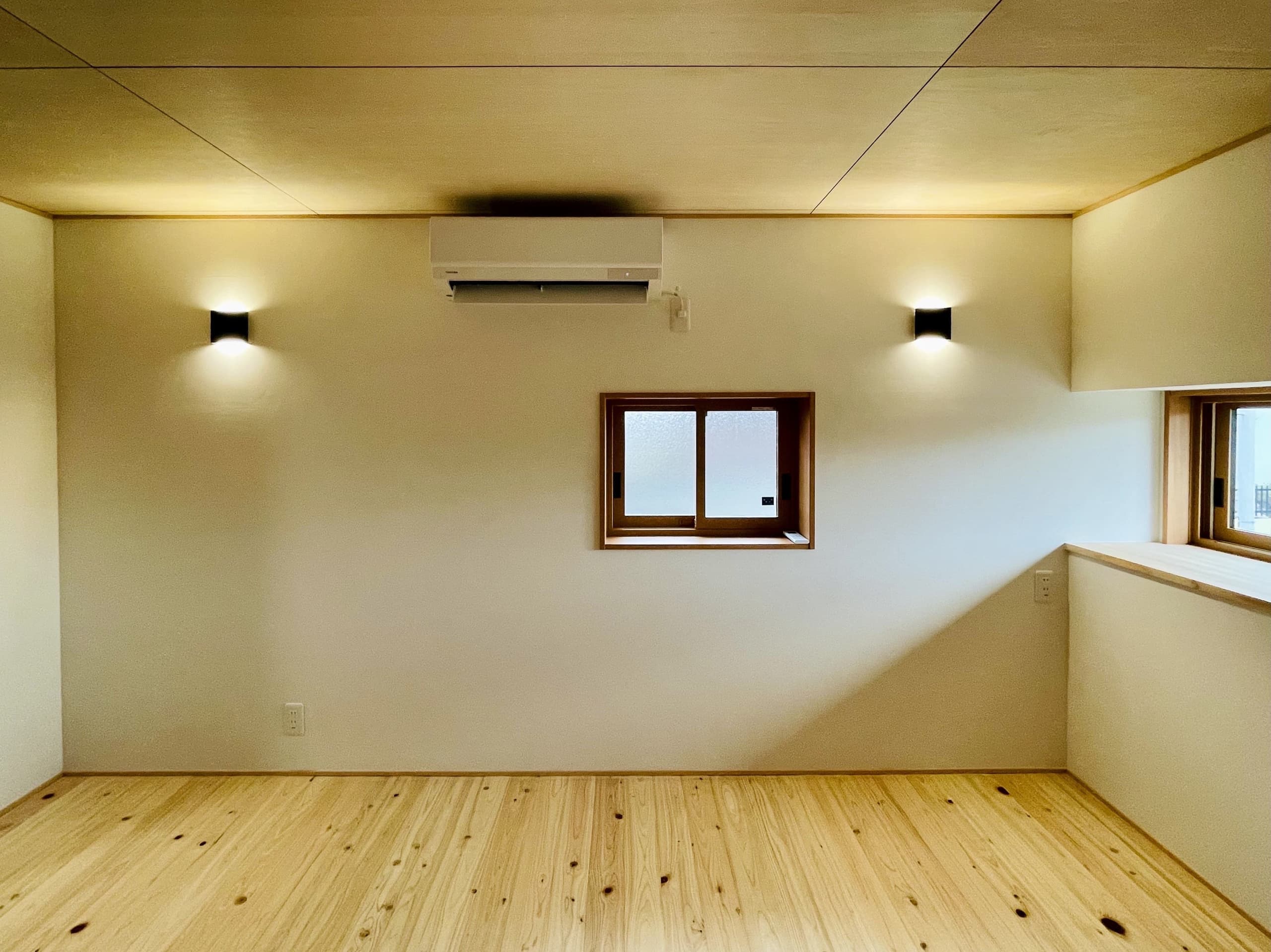 静かな環境を感じさせる、窓から自然光が差し込む寝室